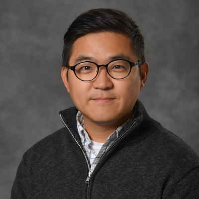 Portrait of Younsuk Dong facing the camera against a neutral gray background